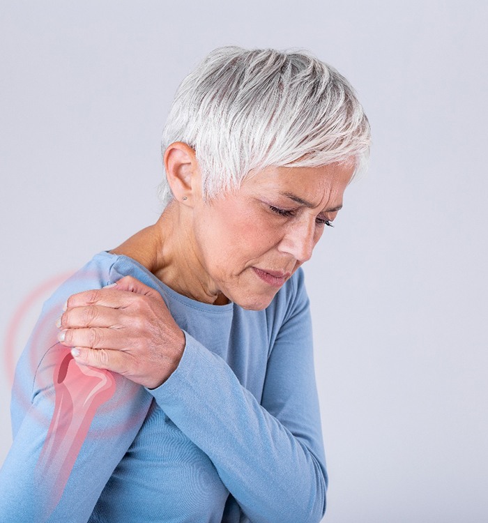Senior woman grimacing due to shoulder pain