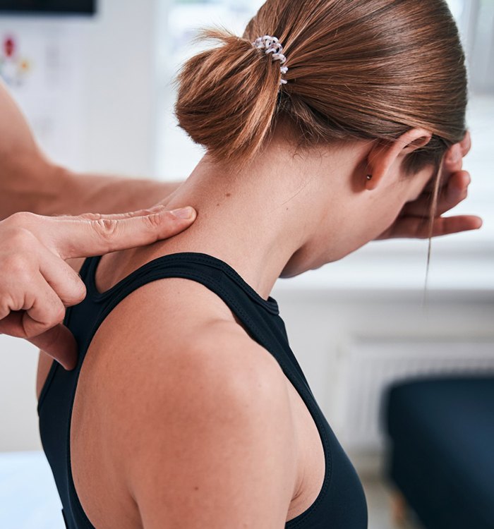 Doctor manipulating patient’s neck during cranial osteopathy session