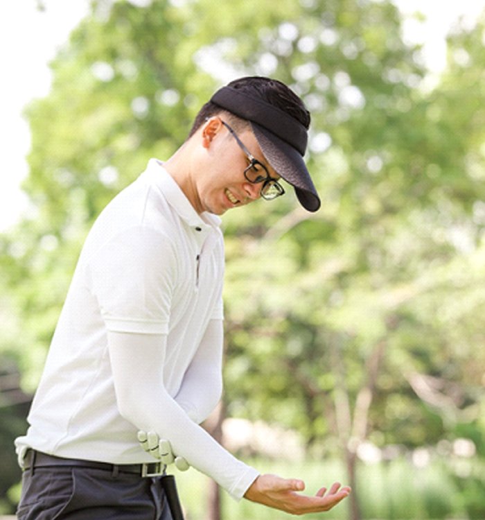 man holding arm on golf course due to Golfer’s elbow