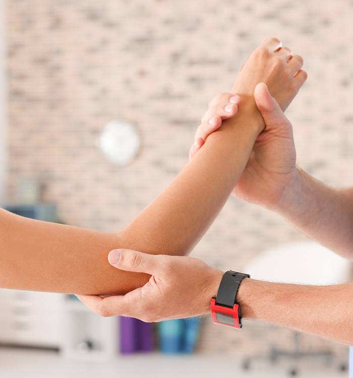 doctor examining a woman’s elbow 