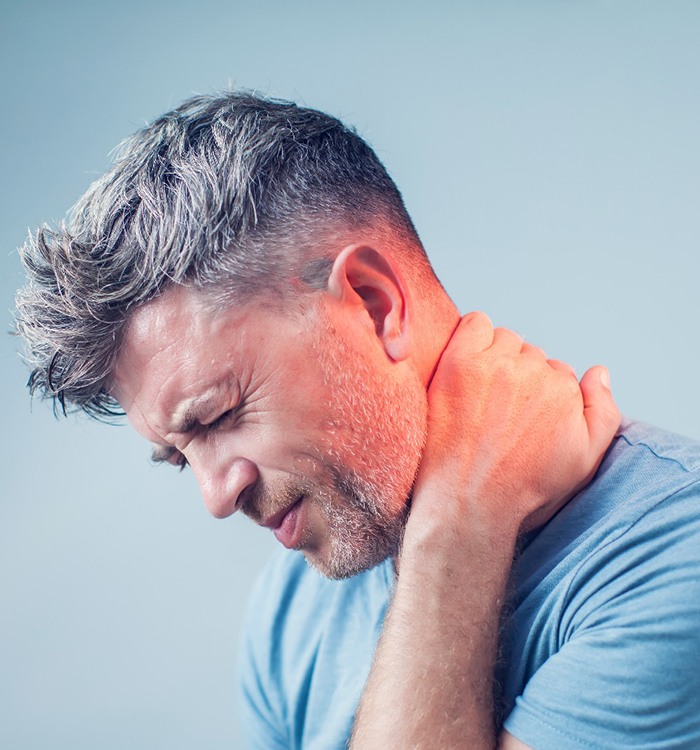 man in workout shirt holding neck 