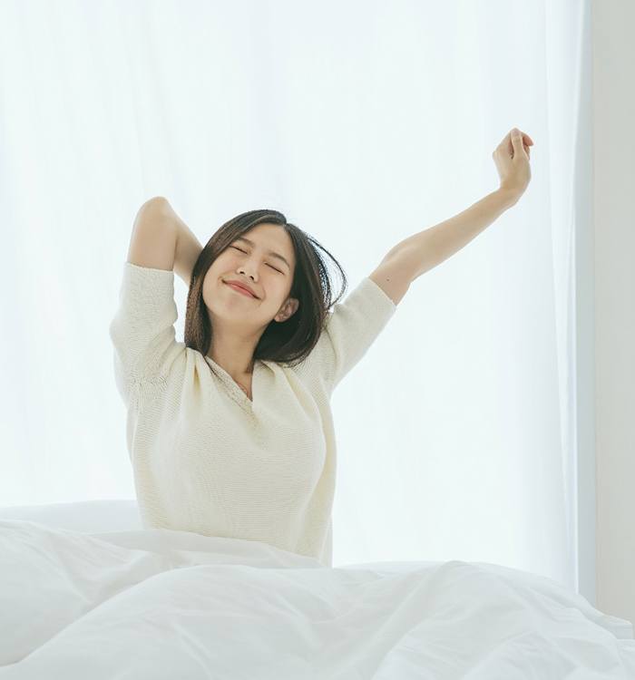 woman waking up and happily stretching 