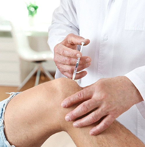 Doctor treating arthritic knee with injection 