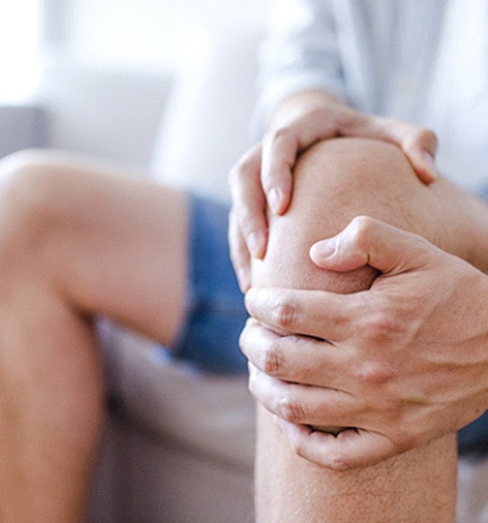 man holding knee due to osteoarthritis 