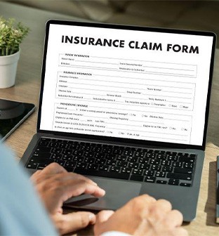 Person filling out insurance claim on their computer