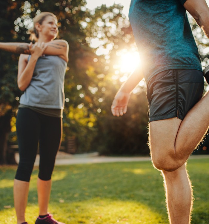 Couple outside, stretching before workout