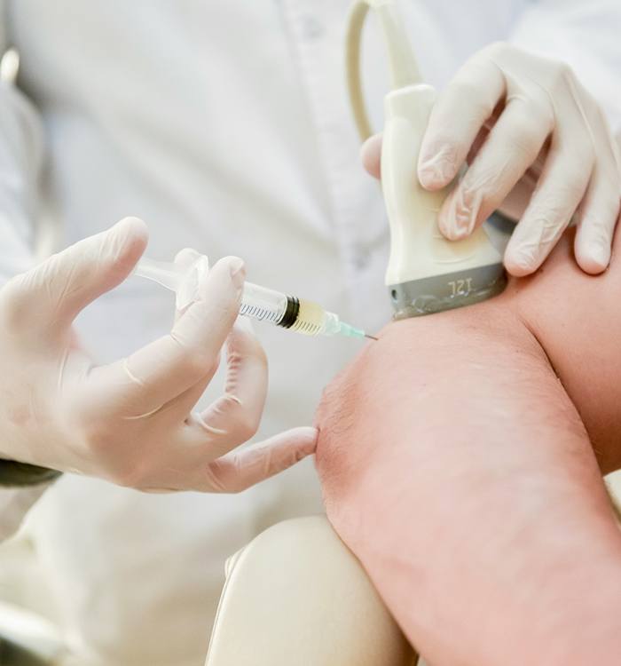 Using a syringe to take sample of patient's blood