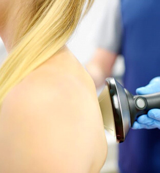 patient receiving shockwave therapy for her back