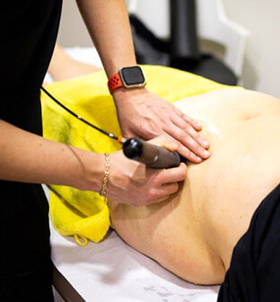 patient receiving shockwave therapy near hip