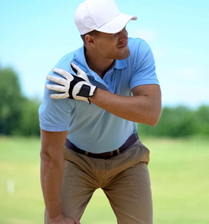 man holding rotator cuff while playing golf
