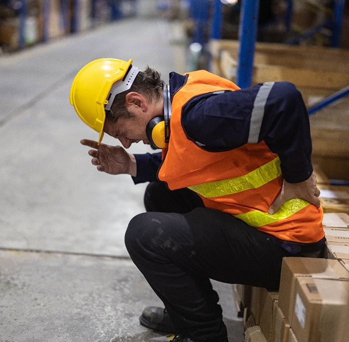 Man suffering pain while working in warehouse