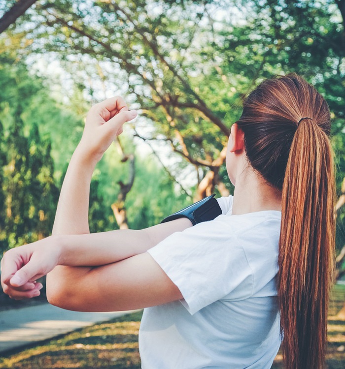 Woman stretching outdoors, enjoying pain-free exercise