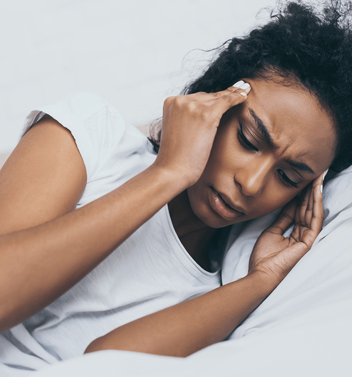 Woman in bed with severe headache