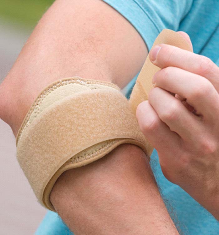 man putting on brace for Tennis Elbow