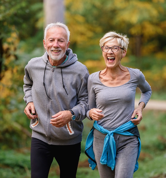 older couple happily jogging outdoors 