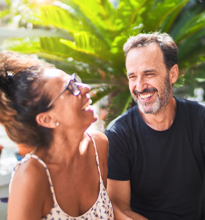 middle-aged couple laughing outdoors 