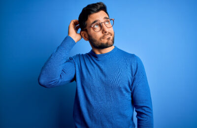 Man in blue t-shirt wearing curious expression.