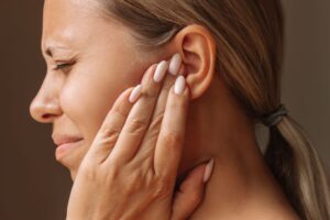 Grimacing woman with ear pain